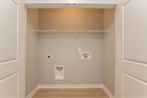 A small, empty room with a single shelf and two light switches.