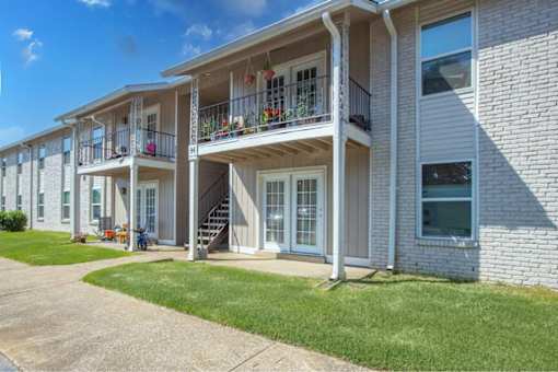 A row of townhouses with balconies and flower pots.