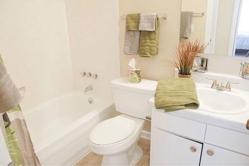 A white toilet sits next to a white sink in a bathroom.