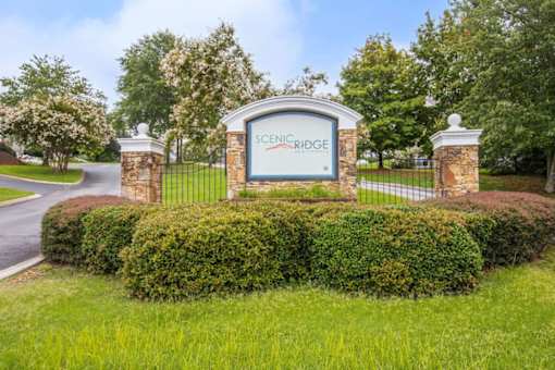 A sign that says Scenic Ridge stands in front of a gate.