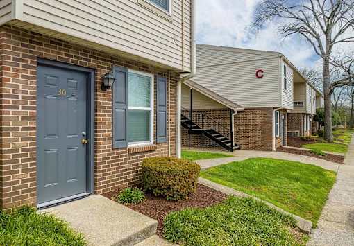 A house with a blue door and a brick wall.