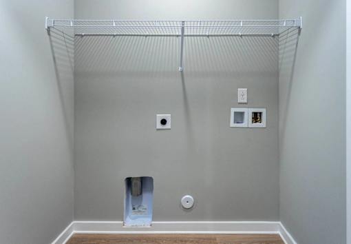 A white wall with a metal rack and a white door.