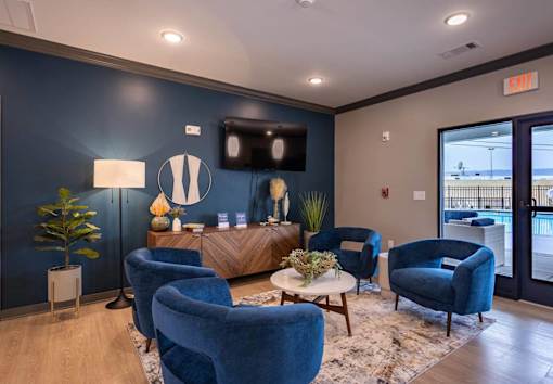 A waiting room with blue chairs and a flat screen TV.