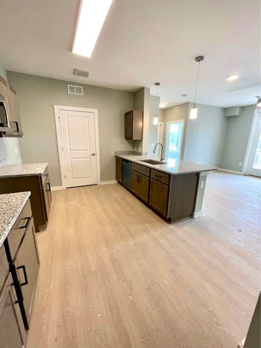 A kitchen with a white door and brown cabinets.