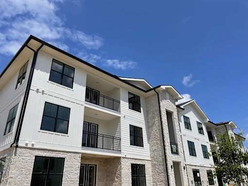 A modern multi-story building with balconies and large windows.