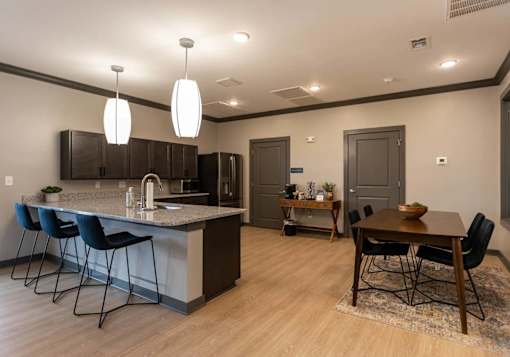 A kitchen with a bar area and a dining table.