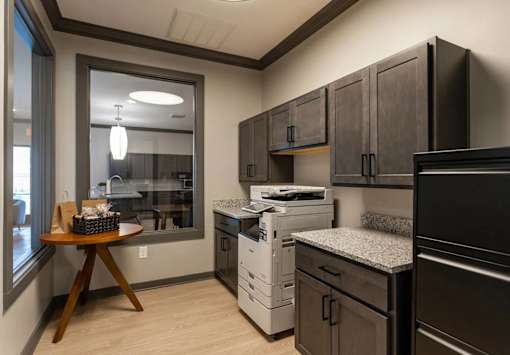 A kitchen with black cabinets and a white dishwasher.