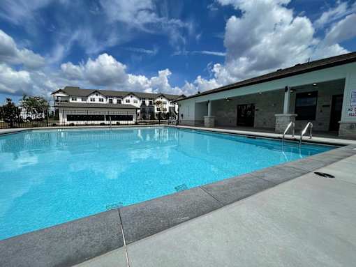 A large swimming pool with a building in the background.