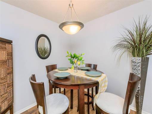 A dining room with a round table set for four.