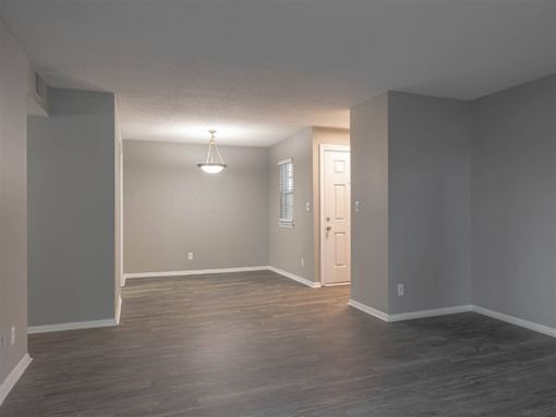 A room with a wooden floor and a white door.