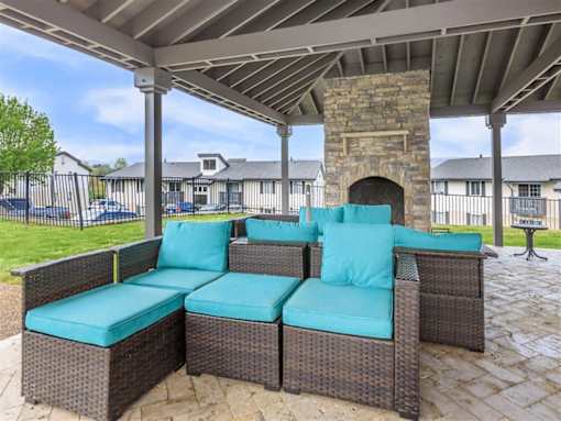 A patio with a couch and a fireplace.