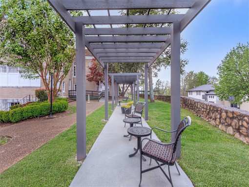 A patio with a table and chairs under a pergola.