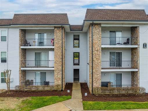 A two-story apartment building with a stone pillar on each side of the entrance.