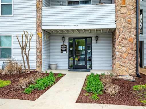 The front of a building with a stone pillar and a glass door.