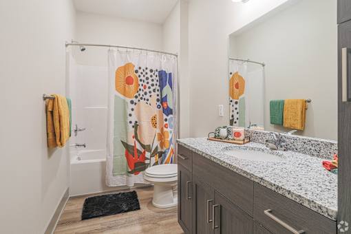 A bathroom with a toilet, sink, and shower curtain.
