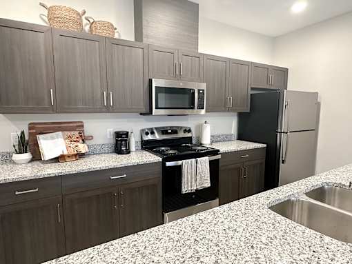 A kitchen with a black stove top oven and a black refrigerator.