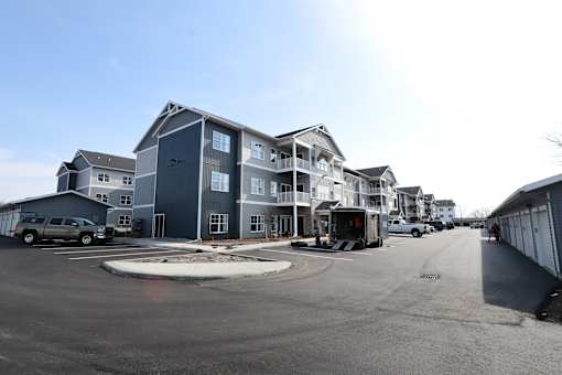 A parking lot in front of a multi-story building.
