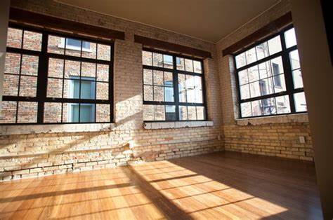 a room filled with lots of windows and a wooden floor