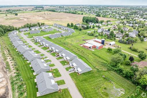 A large, modern building is surrounded by a long row of houses.