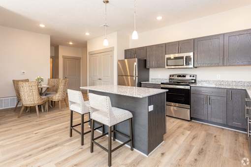 A kitchen with a bar area and a dining table.