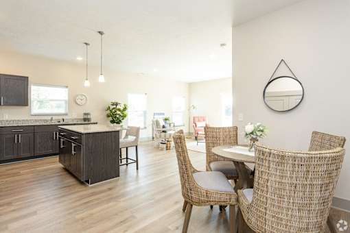 A modern kitchen with a dining table and chairs.