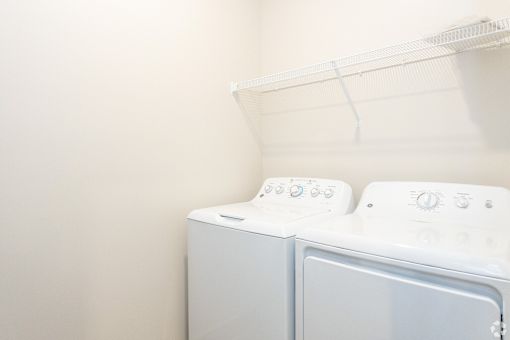 A white washing machine and dryer in a laundry room.