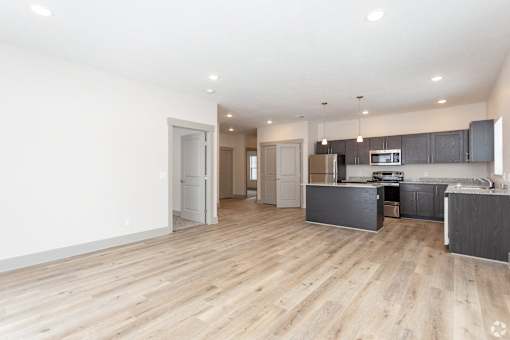 A spacious kitchen with wooden floors and modern appliances.