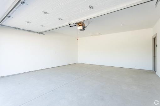 A large, empty room with white walls and a concrete floor.