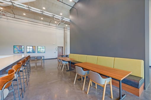 a dining room with tables and chairs and a wall with paintings