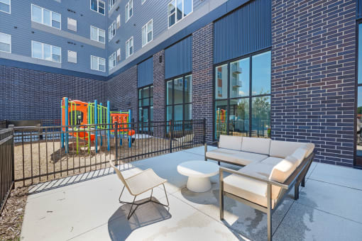 a living room with a couch and a table and a playground with balls and lights