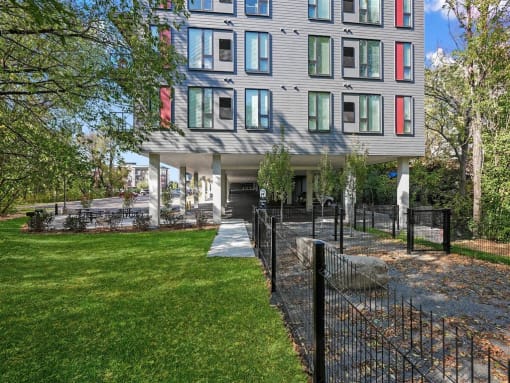 a building with a green lawn and a fence in front of it