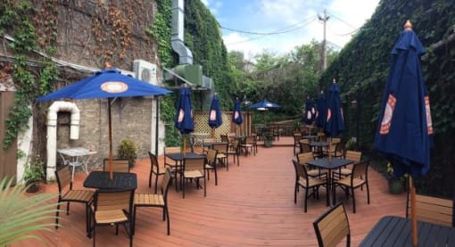 a wooden deck with many tables and umbrellas