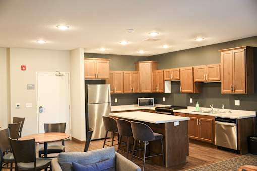 A kitchen with a table and chairs in front of it.