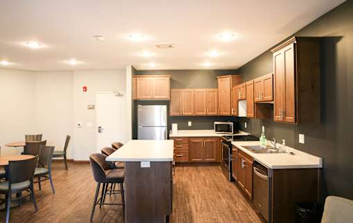 A kitchen with brown cabinets and a white counter.