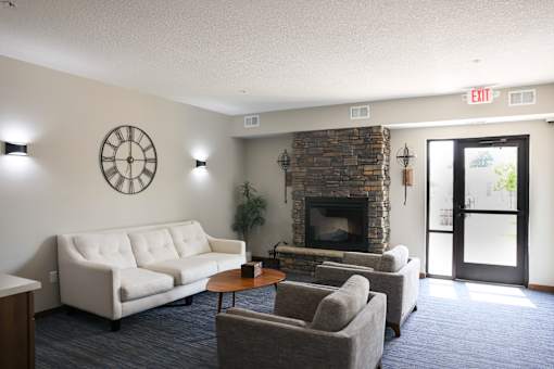 A living room with a couch, chairs, and a fireplace.