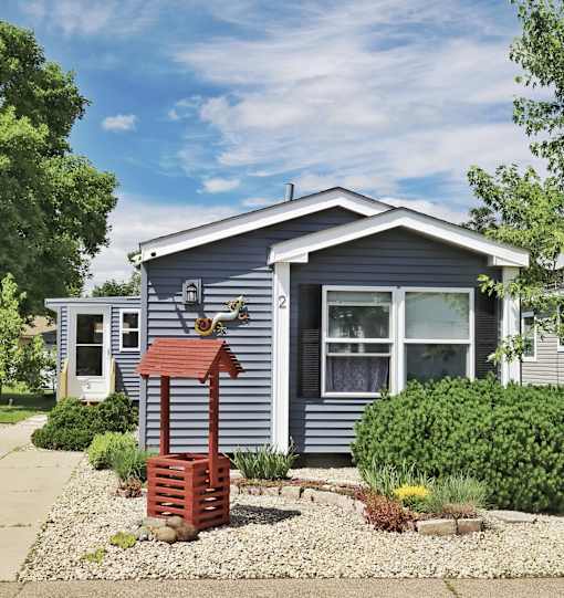 A blue house with a red post and a bird feeder.