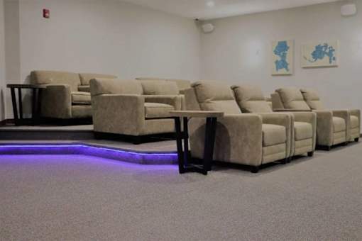 A row of beige couches are lined up in a room.