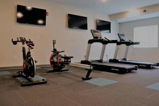 A gym with exercise equipment including treadmills and stationary bikes.