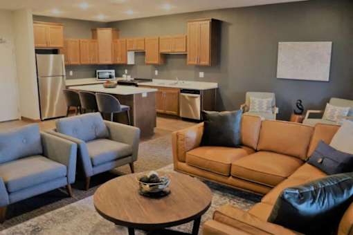 A living room with a couch, chairs, and a coffee table.