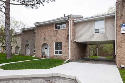 Brick buildings with white doors and a sidewalk in front.