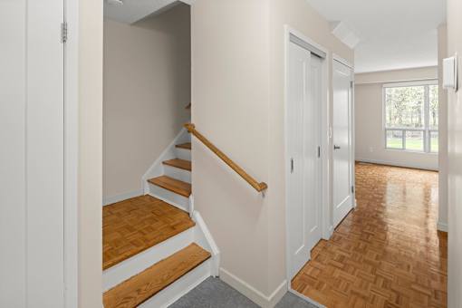 A hallway with a staircase leading to the second floor.