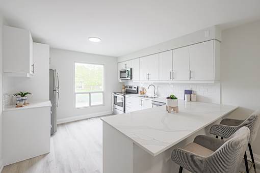 A white kitchen with a table and chairs.