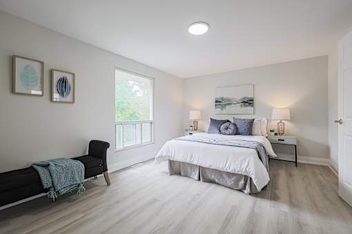 A bedroom with a large bed and a chair.