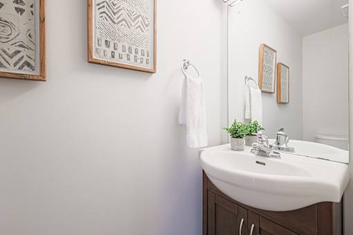 A bathroom with a white sink and a mirror.