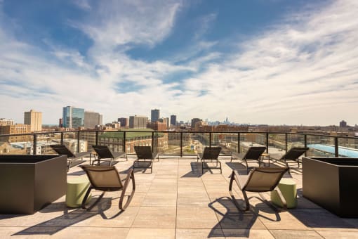 an outdoor terrace with lounge chairs and a pool with a city skyline in the background at Platform 4611, Illinois, 60640