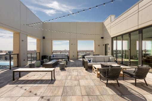 Rooftop terrace with couches tables and chairs and a pool in the background at Platform 4611, Illinois