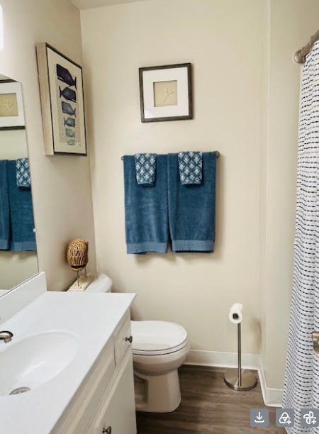A bathroom with a toilet, sink, and towel rack.