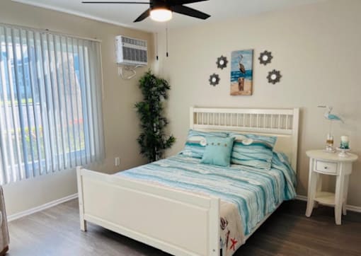 A bedroom with a white bed and a blue and white striped comforter.