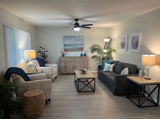 A living room with a ceiling fan and a painting on the wall.
