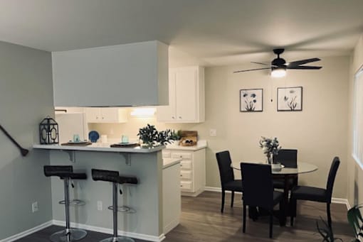 A kitchen with a bar and a dining table.